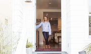 Interior designer Bianca Ecklund in the in the South Bay of southern California  stand in doorway with blue shirt