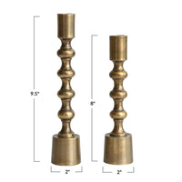 Two brass candle holders with dimensions indicated on a white background