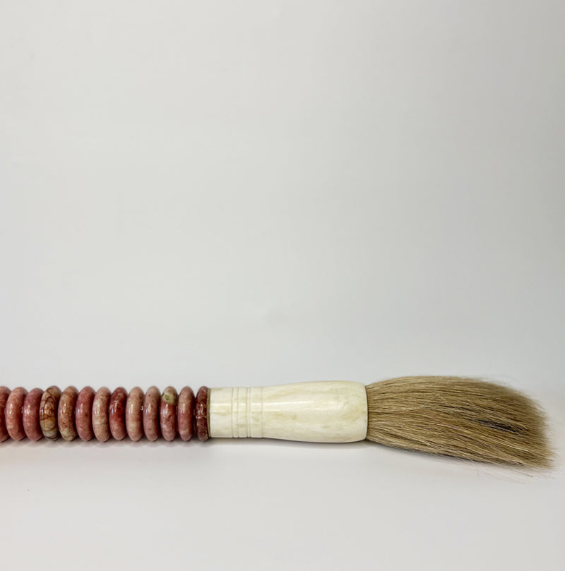 decorate caligraphy brush with  a rosy red hued handle
