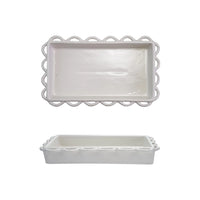 Two white ceramic trays with decorative scalloped edges on a white background