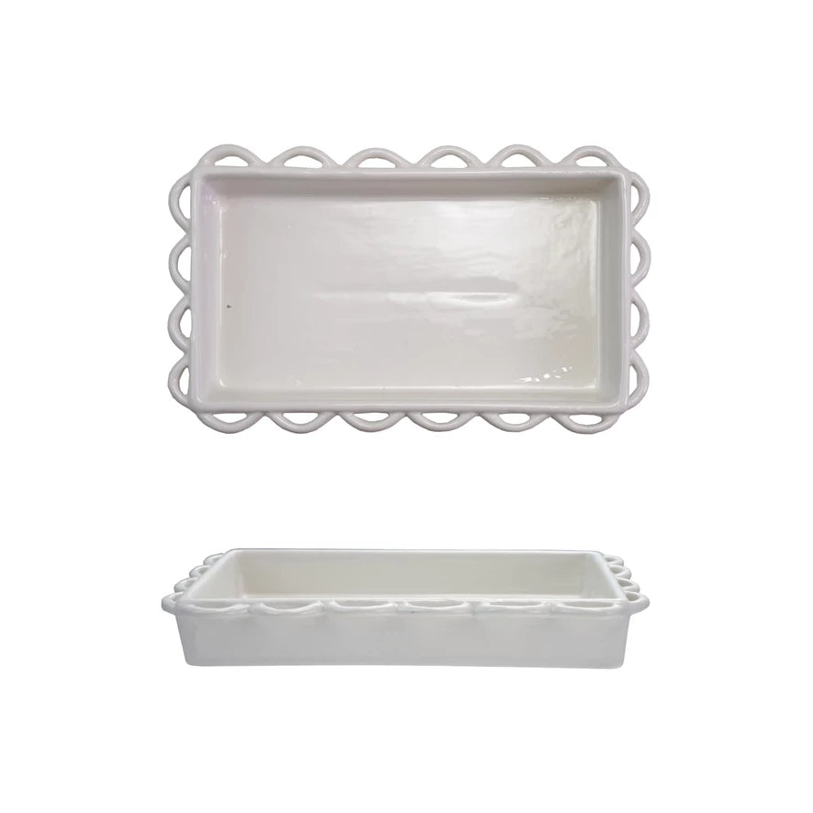 Two white ceramic trays with decorative scalloped edges on a white background