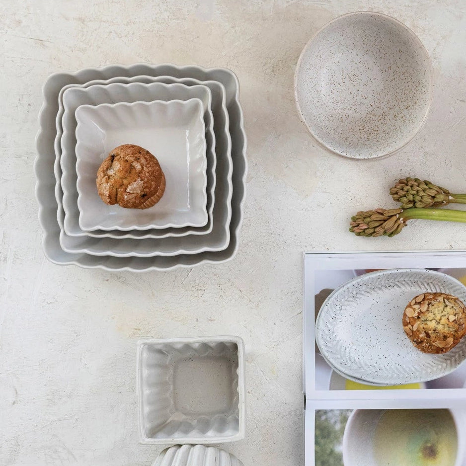 Set of ceramic bowls on a light surface with a photo album in the center.