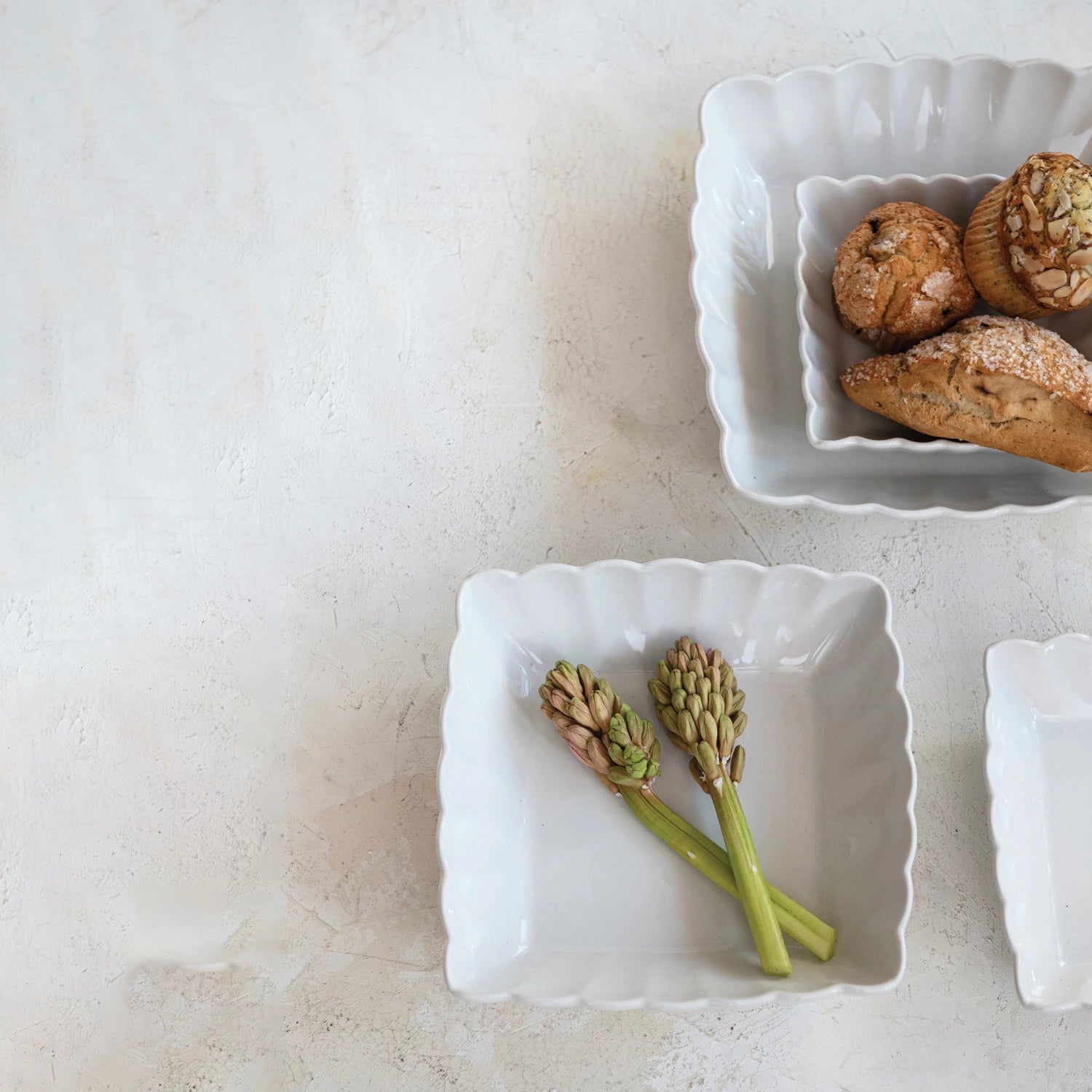 White ceramic dish with green flowers on a light stone surface