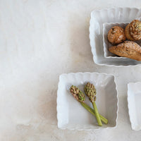 White ceramic dish with green flowers on a light stone surface