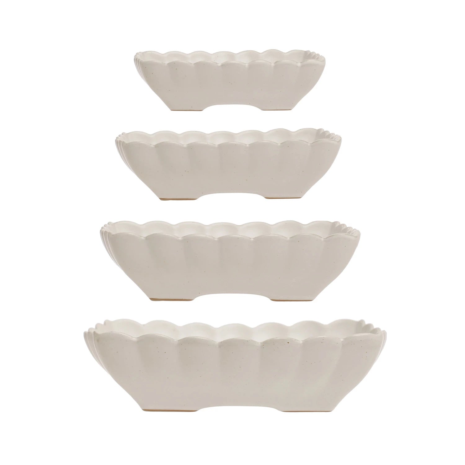 Set of four white ceramic bowls with scalloped edges on a white background