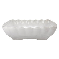 White ceramic bowl with scalloped edge on a white background