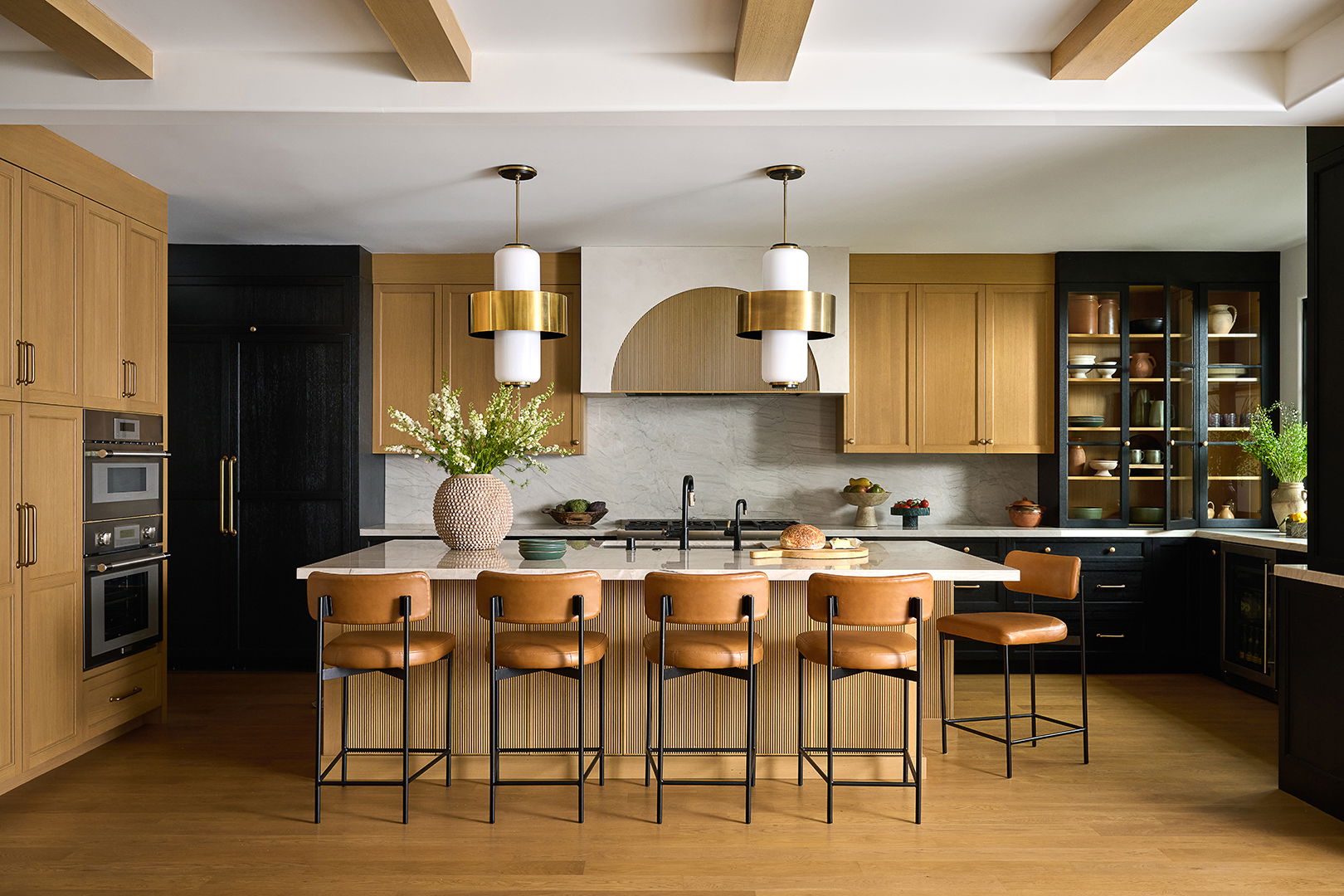 Beautiful modern kitchen with  two- toned cabinetry, large island and modern light pendants