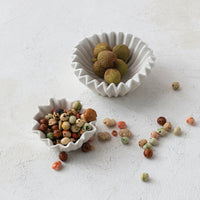 Two ceramic bowls with lychees on a light gray surface