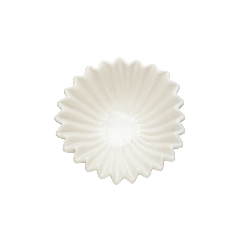 white ceramic bowl with fluted edges on a white background