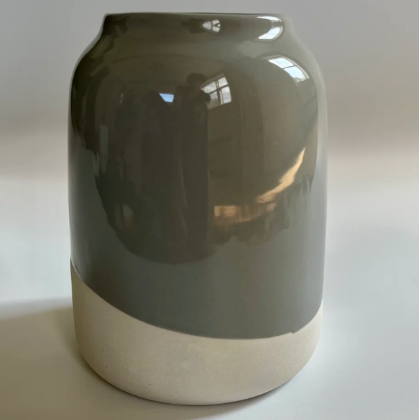 Two-toned ceramic vase with a gradient from gray to white on a plain background