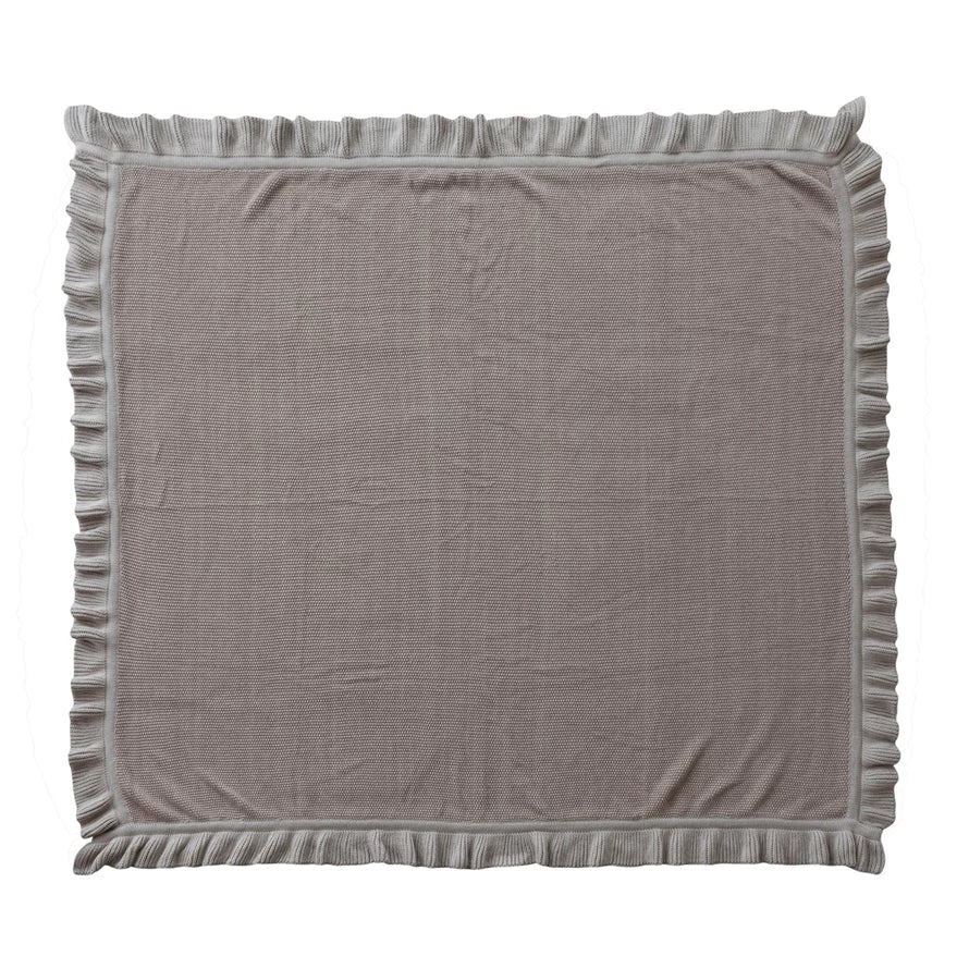 Gray textured blanket with ruffled edges on a white background