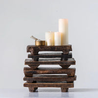 6 stacked wooden pedestals with candles sitting on the top one with a white background